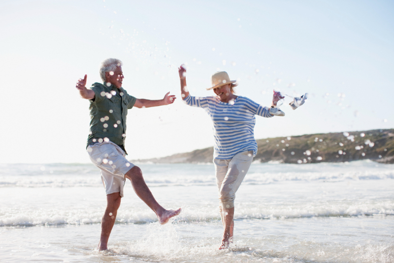 Senior couple splashing in ocean